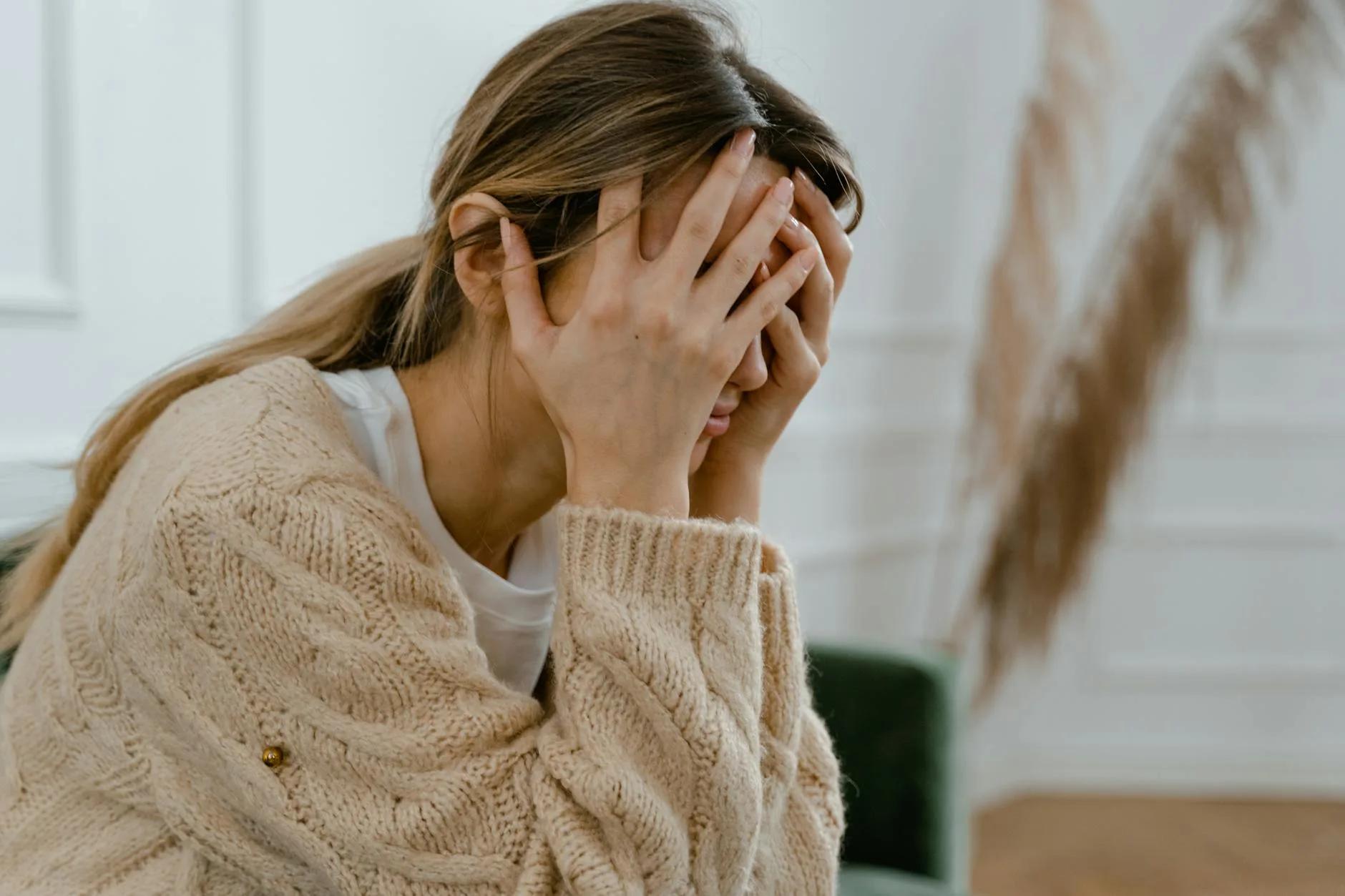 Frustrated person with head in hands
